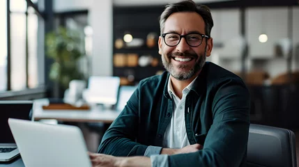 Foto op Plexiglas smiling businessman working with his laptop in the office © Demencial Studies