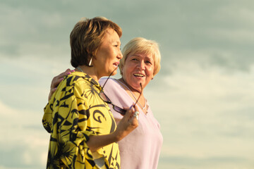 Sunshine embraces two joyful seniors, their laughter echoing warmth; a heartfelt reunion under the open sky.