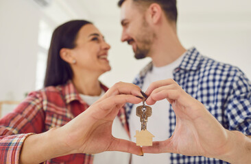 Happy loving family couple buys new house. Blurry background shot of smiling young married man and...