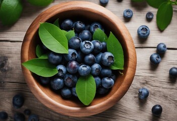 Top view from fresh Vaccinium myrtillus European blueberry and green leaves in a wooden bowl