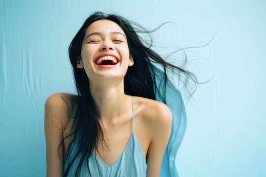 A woman laughing with her hair blowing in the wind