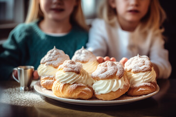 Obraz na płótnie Canvas Children hold a plate of whipped cream-topped Swedish semla buns