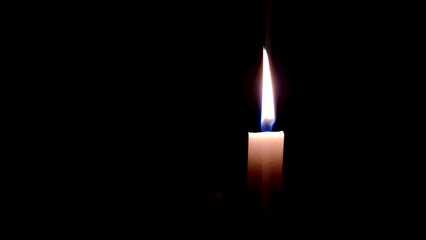 A lone candle burning slowly in the darkness 