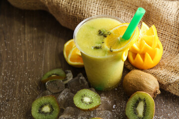 Orange and Kiwi cocktail juice served in disposable glass isolated on table side view of healthy drink