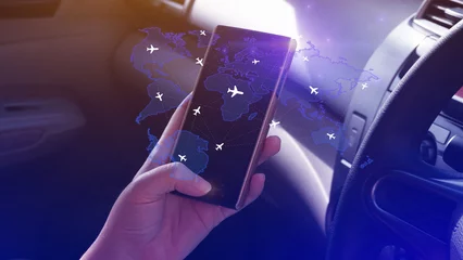 Fotobehang Uses touching flight booking networking on smartphone, Hand pressing light blue world map with flight routes airplane, Transportation concept. © rawintanpin
