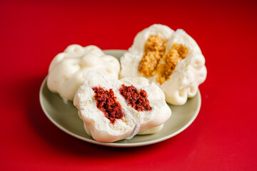Baozi or Bakpao is a type of yeast-leavened filled bun in various Chinese cuisines. Baozi in Red Background