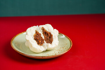 Baozi or Bakpao is a type of yeast-leavened filled bun in various Chinese cuisines. Baozi in Red Background