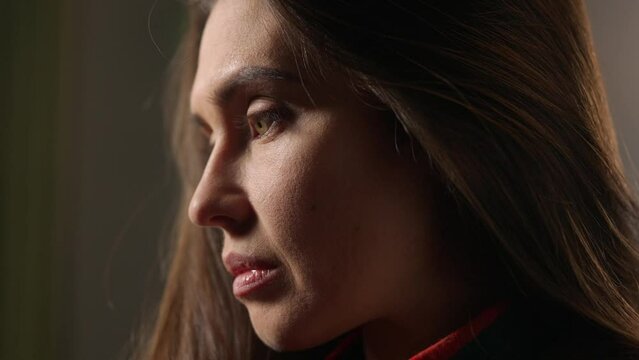 Portrait of attractive female model in negative mood. Close up shot brunette woman face in depressed mood, turns and looking sad at someone.