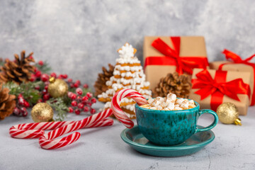 Hot drink with marshmallows and candy cane in  cup on a texture table.Cozy seasonal holidays.Hot cocoa with gingerbread Christmas cookies.Hot chocolate with marshmallow and spices.Copy space.