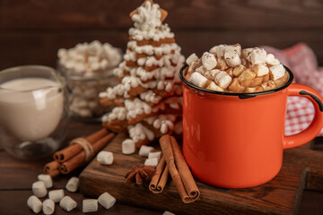 Hot drink with marshmallows and candy cane in  cup on a texture table.Cozy seasonal holidays.Hot...