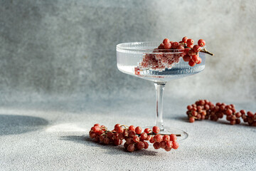 Elegant cocktail glass with grapes on textured background
