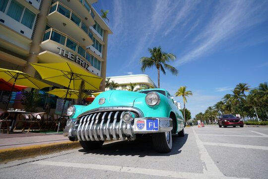 Miami, FL - USA - 11-28-2023: A classic car parked in front of the Fritz Hotel along Ocean Drive in South Beach