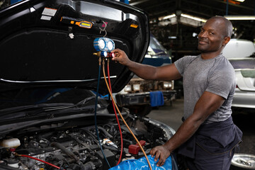 mechanic worker fixing and checking a car air conditioning system in automobile repair shop