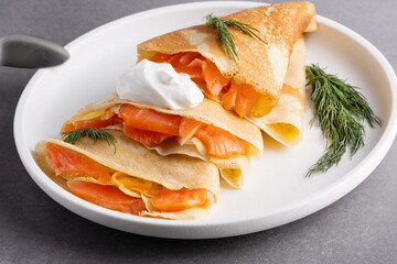 Pancakes with salmon, sour cream and greenstuff. Thin, not sweet blinchiki stuffed with red fish. Feast of Maslenitsa