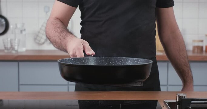 Chef roasting fresh rosemary and garlic in a frying pan to cook steak. Cooking meat steak with rosemary and garlic at home. Slow motion