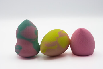 Multicolored beauty blenders. Three sponges for applying makeup on white background