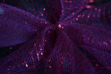Macro of purple bow with red sparkly parts, on Christmas tree