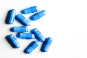 Medicine background. Blue pills isolated on white. Pile of capsules. Tablets background. Vibrant vivid color drugs. Antibiotics background. Group of drugs. Empty copy space medical background.