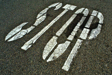 Cracked paint forms pattern on “Stop” letters at country road intersection 