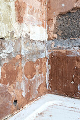 Damaged damp plaster exposing brick in a bathroom. Home improvement problems concept
