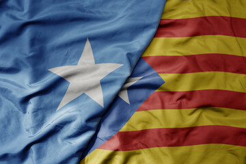 big waving national colorful flag of catalonia and national flag of somalia .