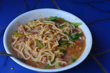 Photo of chicken noodles topped with dumplings, soy sauce chicken and mustard greens