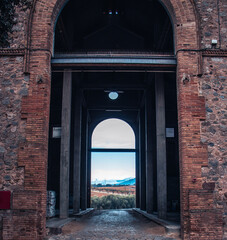View from arched door looking out into the field photo. An arch through which you can see the...