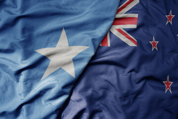 big waving national colorful flag of new zealand and national flag of somalia .
