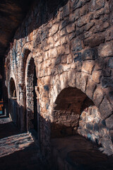 Old brick wall niches in church photo. Black door leading in ancient church photography. Sant Miquel del Fai monastery