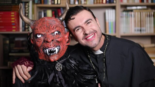Man and friend dressed as demon and priest for Halloween 