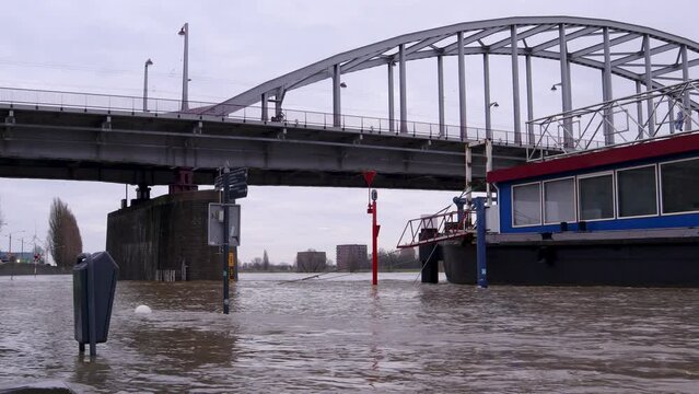 Flooding of the river Rhine, Arnhem, the Netherlands. In the background the John Frost bridge. The road is not accessible because of the high water level.