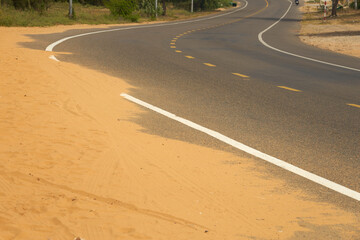 Desert sand steps on an asphalt road.