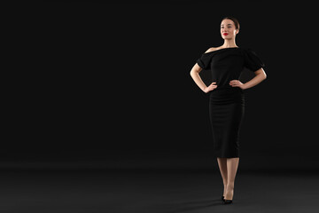 Obraz premium Beautiful young woman on black background, space for text