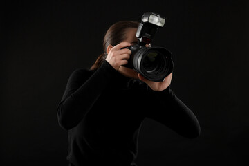 Professional photographer taking picture on black background