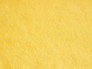 Stitched seam on yellow fabric textile background close-up