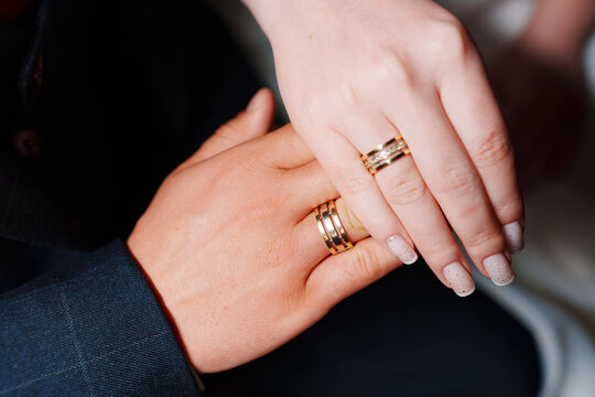 Female and male hand with wedding rings.