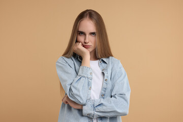 Portrait of resentful woman on beige background