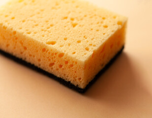 Cleaning sponge on a peach fuzz color background. Cleaning concept, cleaning service.Top view