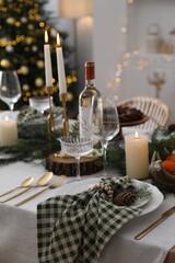 Christmas table setting with festive decor and dishware in room