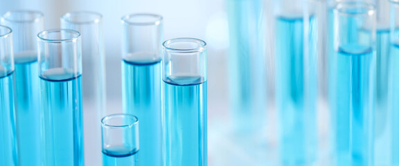 Laboratory analysis. Test tubes with liquid samples against blurred background, closeup. Banner design with space for text