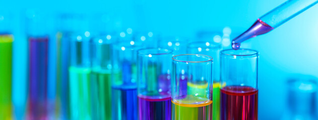 Laboratory analysis. Dripping reagent into test tube on light blue background, closeup. Banner design with space for text