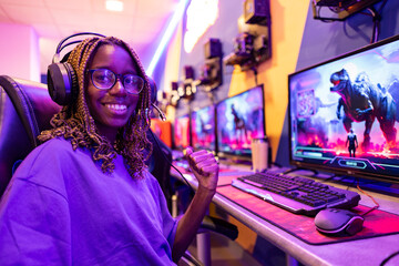 closeup portrait of young african american gamer with glasses and braided hair looking at camera...