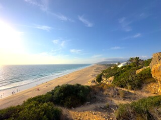 view from a cliff over the beautiful endless sandy beach between Atlanterra, Zahara de los Atunes and Barbate at the Costa de la Luz at the sunset, Andalusia, Spain