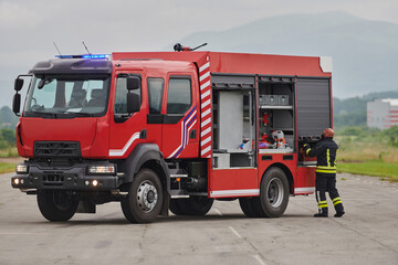 A firefighter meticulously prepares a modern firetruck for a mission to evacuate and respond to...