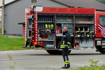 A firefighter meticulously prepares a modern firetruck for a mission to evacuate and respond to...