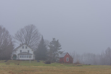 Landscape with farm of the Canadian countryside in Quebec on a foggy day