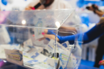 Process of prize drawings, extracting a winning numbers of lottery machine, raffle drum with a bingo balls, bingo machine and winning tickets on event with a host, hands on lottery machine