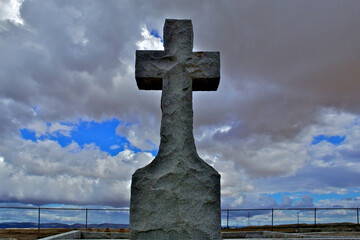 View up at Hand shaped granite stone cross on a cloudy day , Pioneer Cemetery, Central Valley, California 