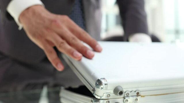 Businessman opens a suitcase full of dollar bills close-up. Bribe on large scale concept