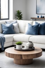 Fototapeta na wymiar Minimalist interior design of modern living room in home. Close-up of a wooden accent coffee table near a white sofa with blue and gray pillows.